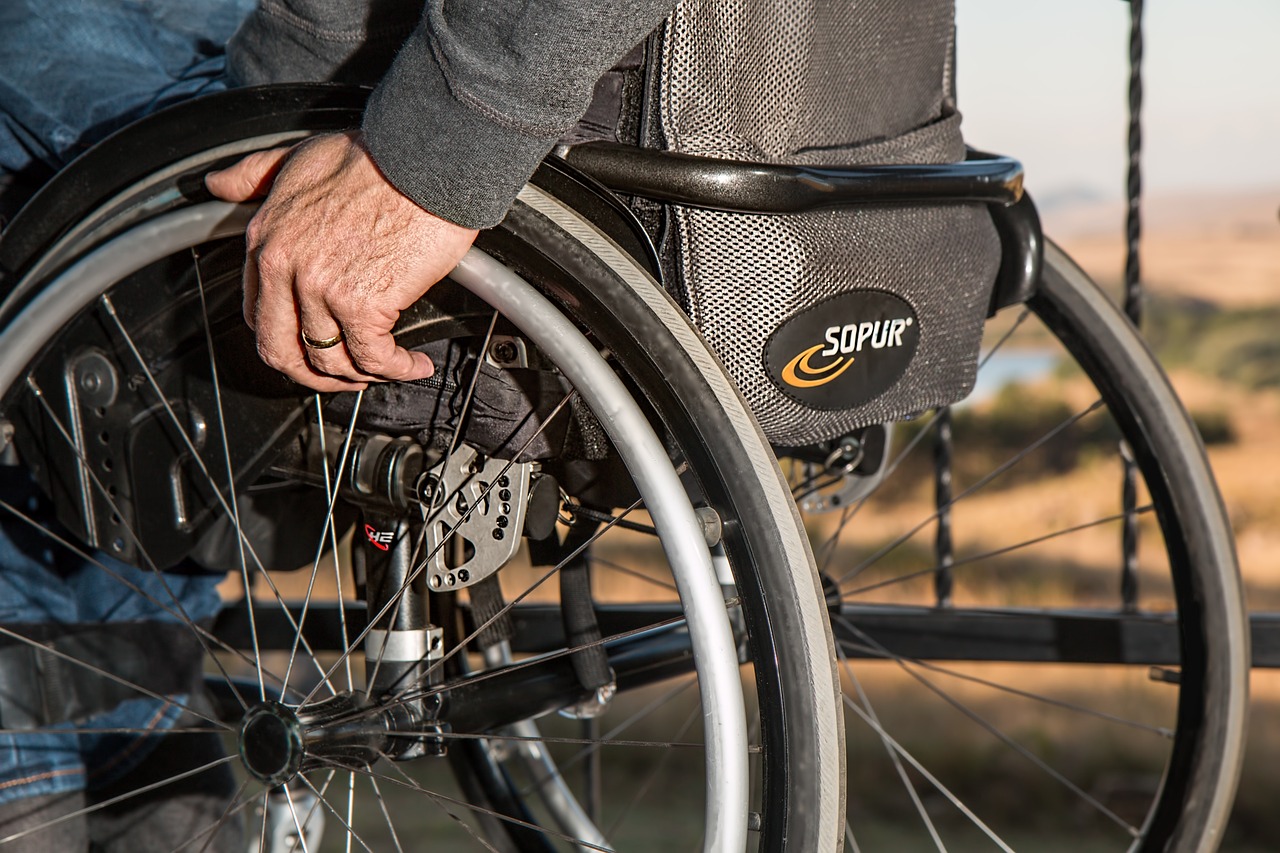 Person using a wheelchair outdoors in a park setting